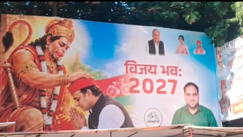 सपा कार्यालय के बाहर लगा पोस्टर, लिखा- ‘विजय भवः 2027’; अखिलेश यादव को हनुमान जी का आशीर्वाद देते दिखाया